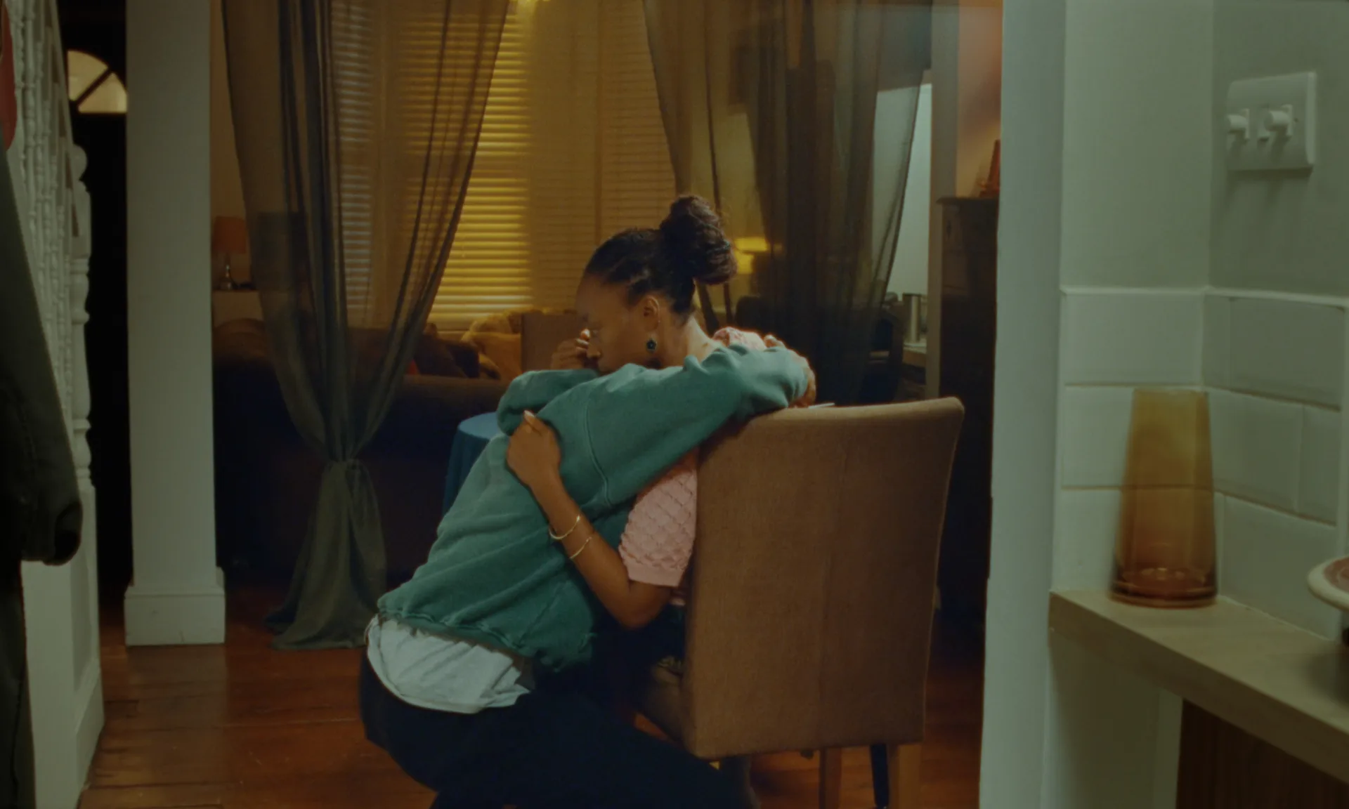 At This Moment, It's Us — mother and son embracing by the table
